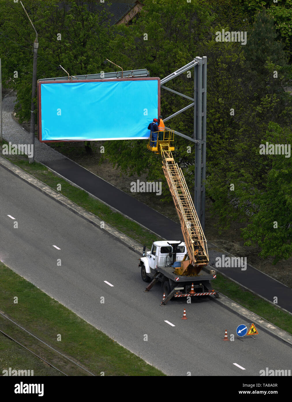 Workers Installing blank blue billboard outdoor vertical Stock Photo