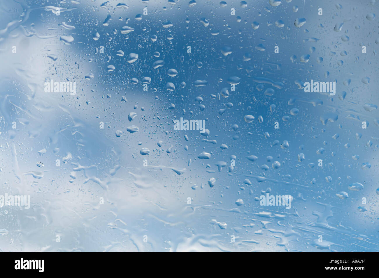 raindrops on a window a blue sky of a cloud Stock Photo