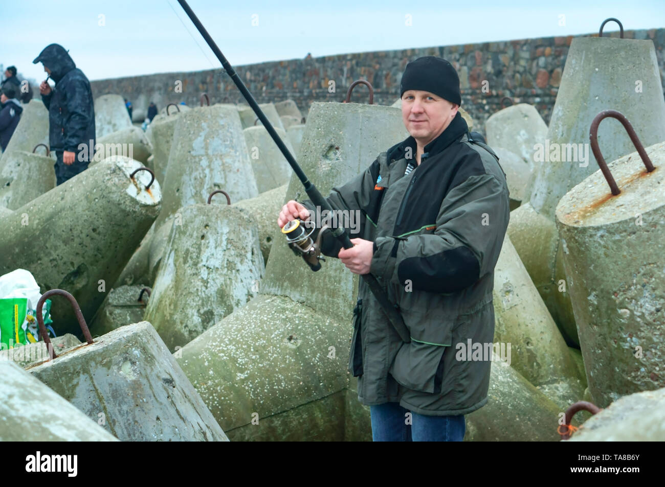 people fishing from the sea pier, fishermen on the pier, Baltiysk, Kaliningrad region, Russia, March 21, 2019 Stock Photo