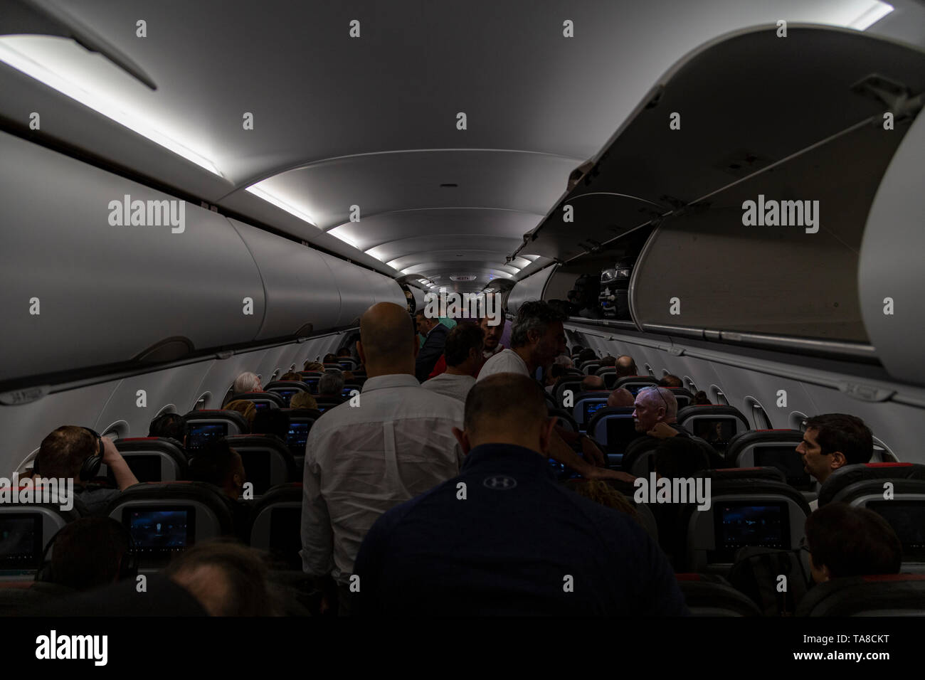 Interior of airplane with passengers get on board Stock Photo