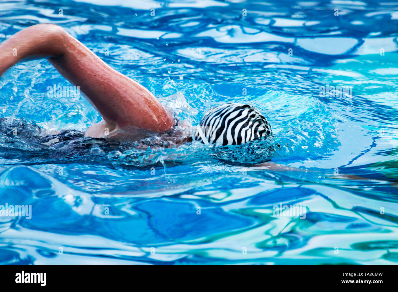 A women swims face down in a very blue pool Stock Photo Alamy