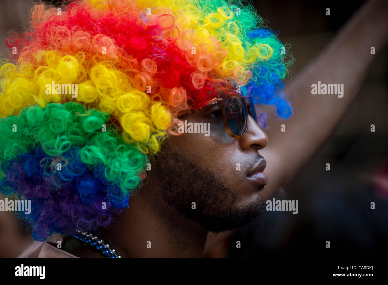 NEW YORK CITY - JUNE 25, 2017: A spectator wears an Afro wig in rainbow colors on the sidelines of the annual Pride Parade in Greenwich Village. Stock Photo