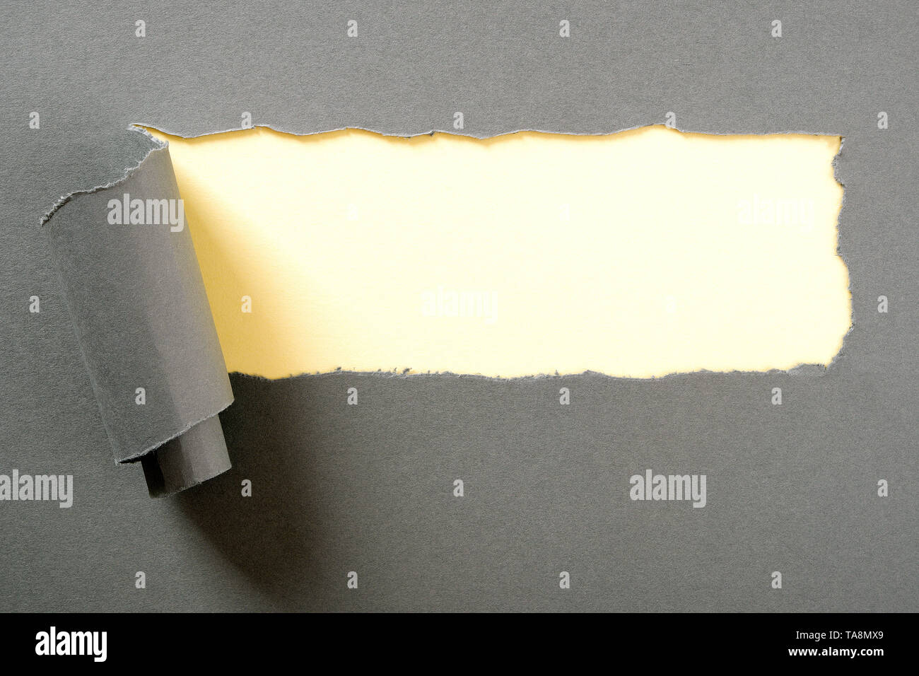 Gray paper torn ripped strip yellow background Stock Photo