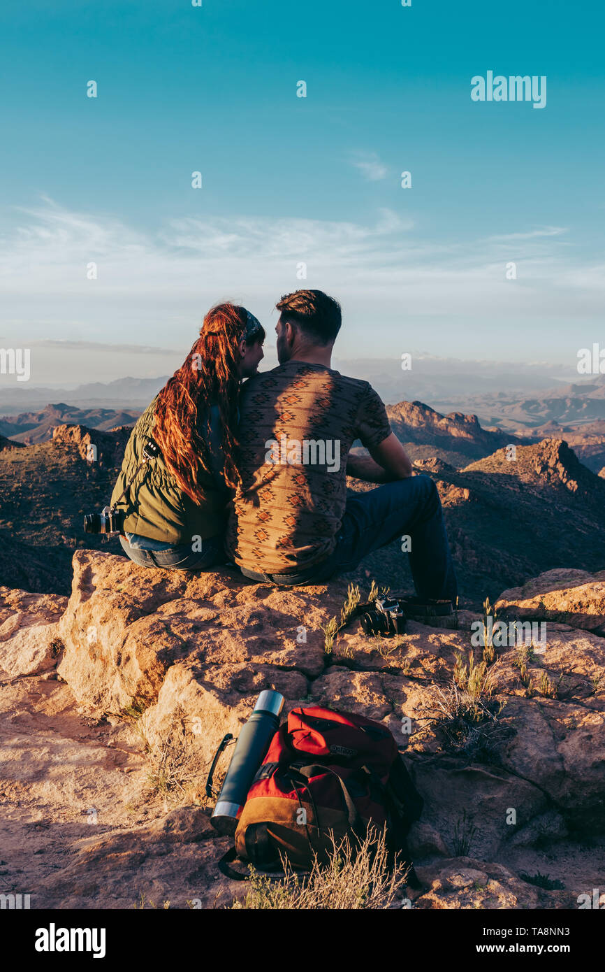 Hiking couple taking a break on desert mountain Stock Photo - Alamy