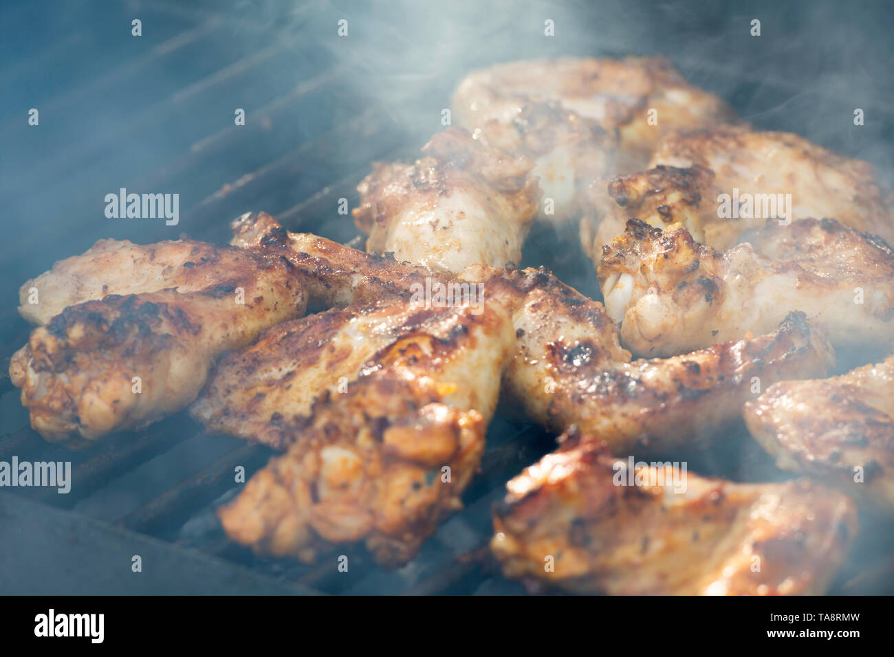 grilling chicken wings on bbq  for a party at a backyard, outdoor Stock Photo