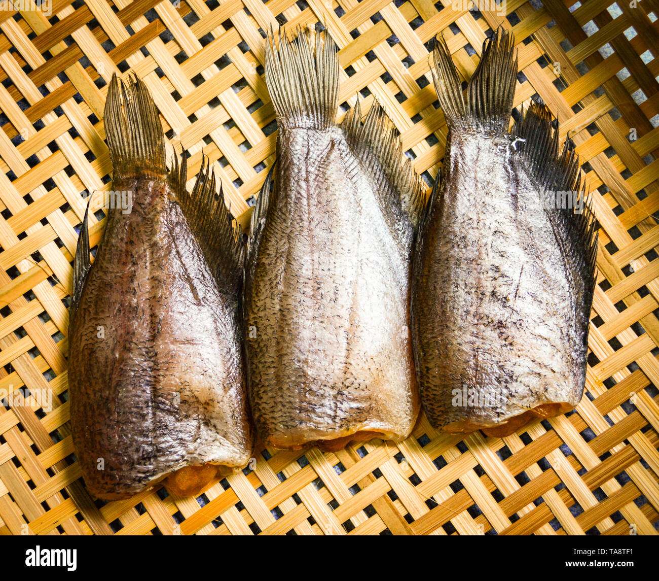 Sun dried fish / trichogaster pectoralis fish dry with spawn on bamboo basket Stock Photo