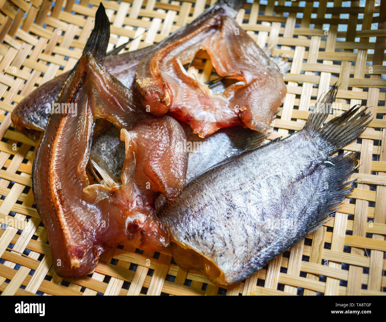 Sun dried fish / trichogaster pectoralis fish and striped snakehead fish dry on bamboo basket Stock Photo