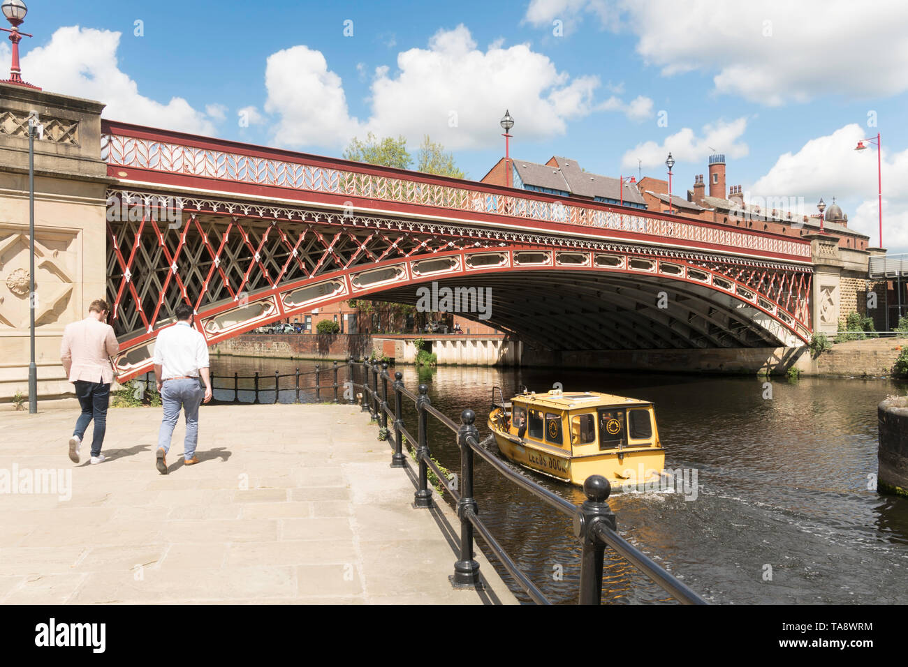 A Leeds Dock water taxi passes under the Crown Point Bridge over the river Aire in Leeds, Yorkshire, England, UK Stock Photo