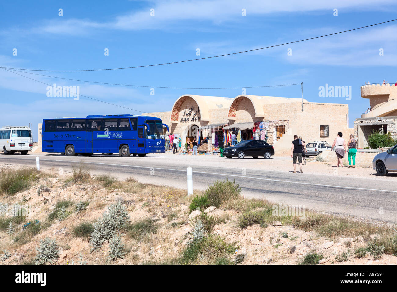 TOZEUR, TUNISIA-CIRCA MAY, 2012: High-decker coach of the Pegas Touristik stops on the road near cafe for passenger rest. It is Russian tour operator  Stock Photo