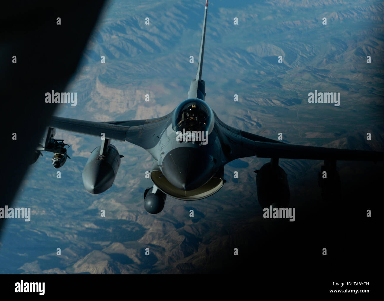 A U.S. Air Force F-16 Fighting Falcon prepares to connect with a KC-135 Stratotanker assigned to the 340th Expeditionary Air Refueling Squadron out of Kandahar Airfield, Afghanistan, during an aerial refueling mission above an undisclosed location May 14, 2019. The F-16 fills a critical role of enabling local security, and close air support to coalition forces on the ground. (U.S. Air Force photo by Staff Sgt. Chris Drzazgowski) Stock Photo
