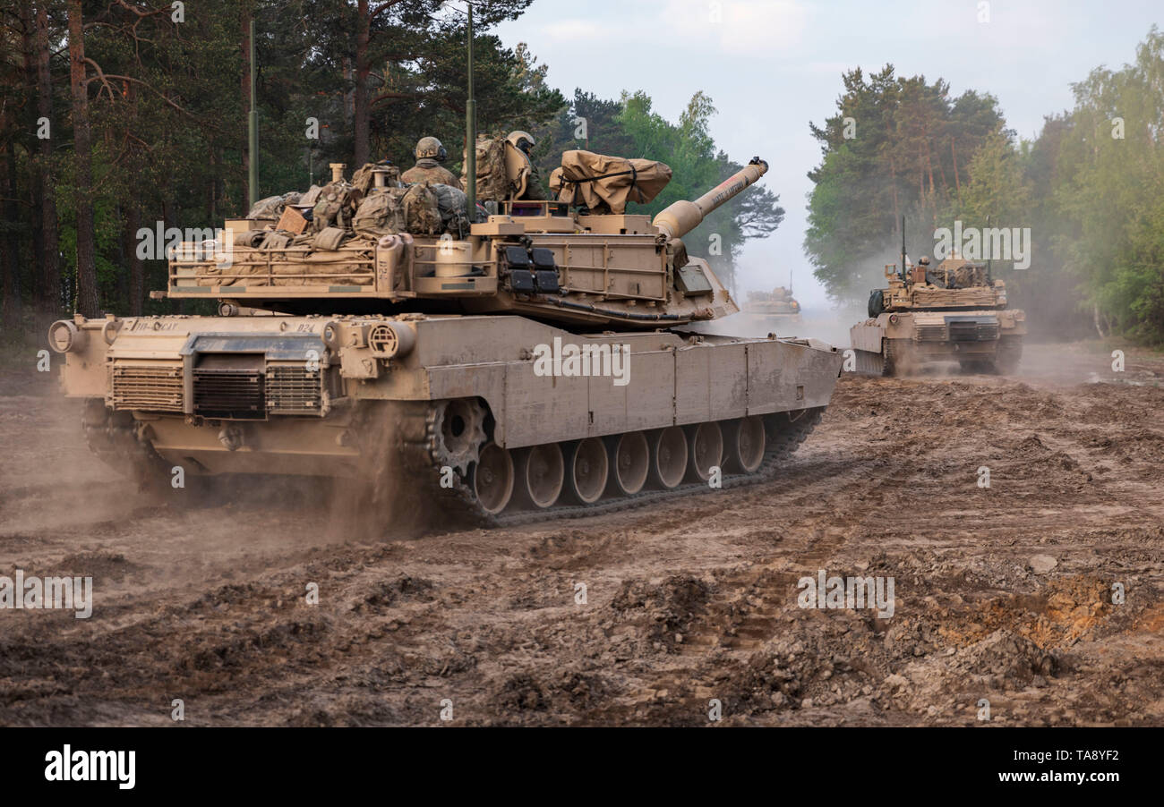 Soldiers aboard M1A2 Abram Tanks from 1st Squadron, 4th Cavalry Regiment, 1st Armored Brigade Combat Team, 1st Infantry Division move out, as part of an Initial Ready Task Force (IRTF) exercise, at Johanna Range, Poland, May 20, 2019. An IRTF is a no-notice, rapid-deployment exercise designed to test a unit's ability to alert, marshal, and deploy forces and equipment for contingency operations or an emergency disaster. (U.S. Army photo by Sgt. Thomas Mort) Stock Photo