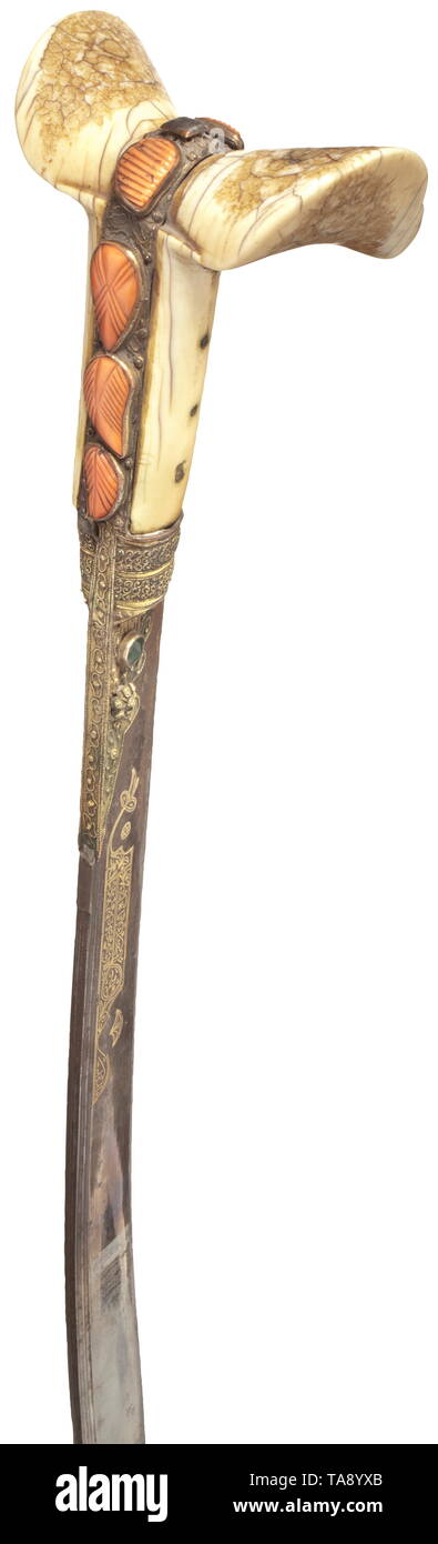 An Ottoman gold-inlaid yataghan, dated 1827 Typically curved blade with chiselled back and double fullers, with (old) blued root on both sides. The obverse side with a circular, gold-inlaid inscription, on the reverse a two-line cartouche with manufacturer's inscription and date '1243' (=1827). The gilt blade mounting set with filigree and glass beads, the grip frame set with cut corals. Riveted, intact walrus ivory grip panels. The leather-covered wooden scabbard stitched with wire, with iron fittings (rust film). The leather damaged in places. , Additional-Rights-Clearance-Info-Not-Available Stock Photo