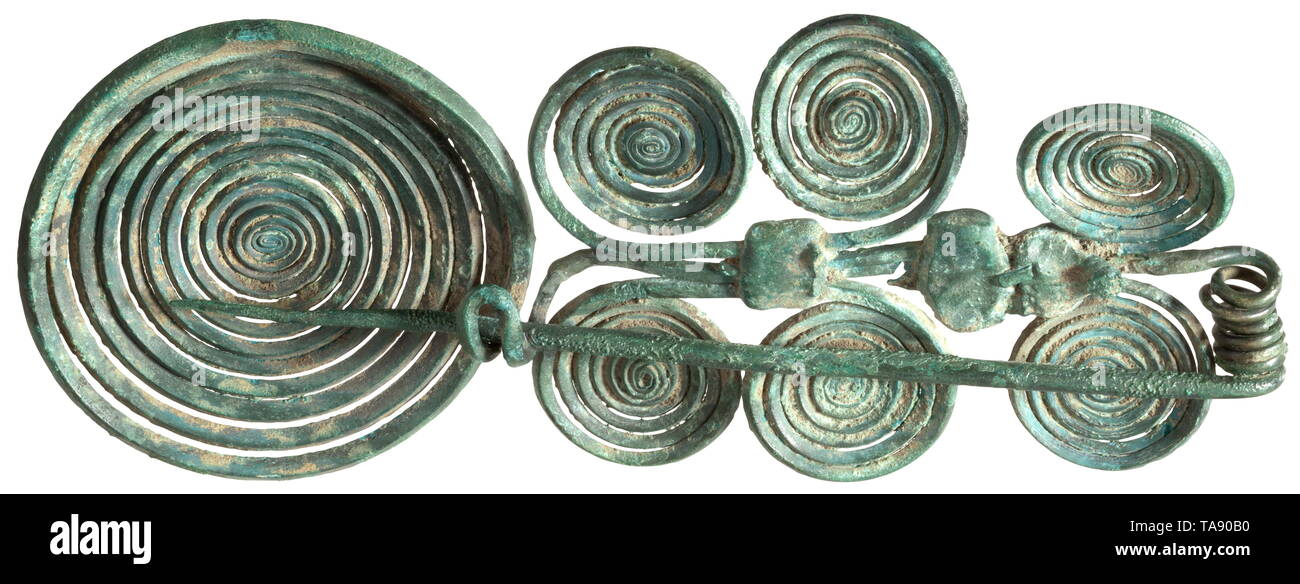 A Southeast European fibula with spirals, Early Urnfield Period, 12th to 11th century BC Fibula made of five wires held together by three sheet metal strips. Thick wire with closure and large spiral, two double spirals and two single spirals added on the side. Length 20.02 cm. Beautiful dark green, partially rough patina. Superbly preserved, undamaged exemplar. Provenance: Viennese private collection, acquired in the 1990s in art trade. historic, historical, prehistory, Additional-Rights-Clearance-Info-Not-Available Stock Photo
