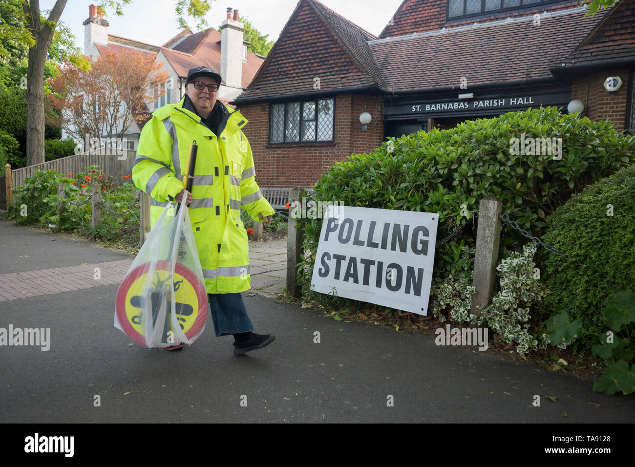 On the morning of the European Elections in the UK, a lollipop lady carries her pedestrian sign past the Polling Station at St. Barnabas Parish Hall in Dulwich Village, on 23rd May 2019, in south London, England UK. Stock Photo