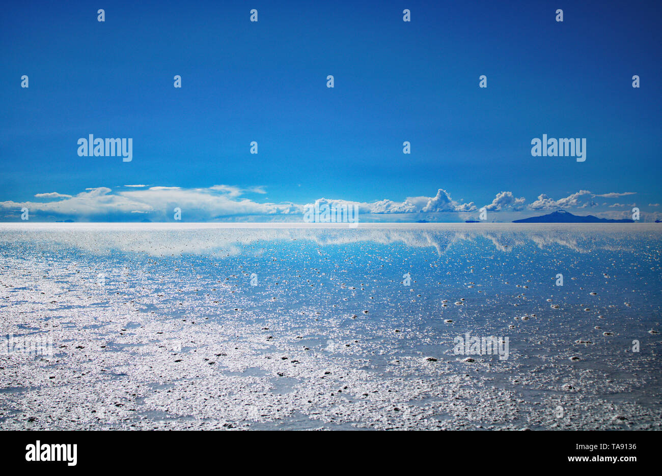 Uyuni Saltflats during rainy season. Mirror effect reflecting the clouds Stock Photo