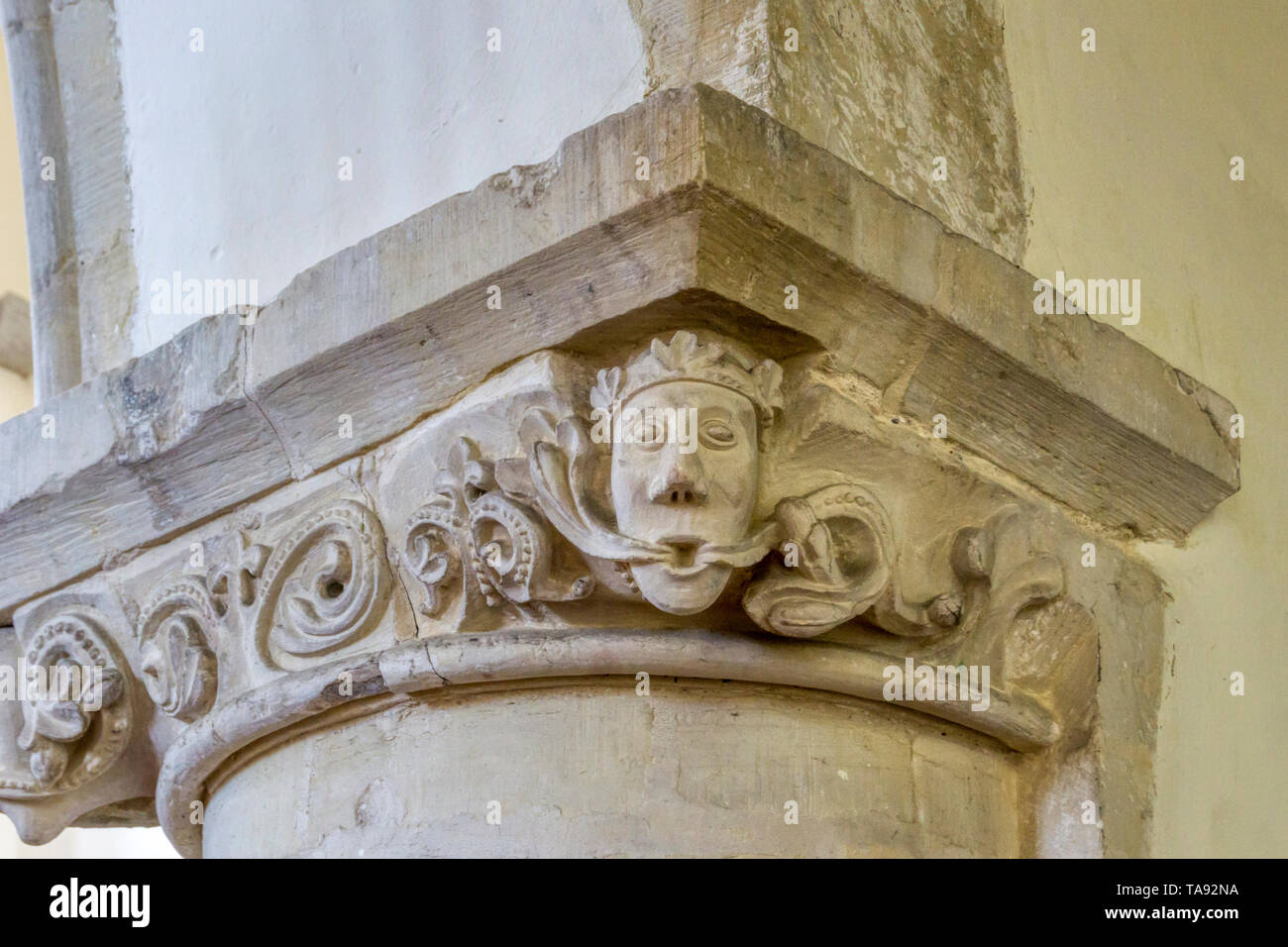 Unusual Green King or Crowned Green Man carved on the capital of a Norman pillar in St Nicholas church at St Nicholas-at-Wade in Kent. Stock Photo