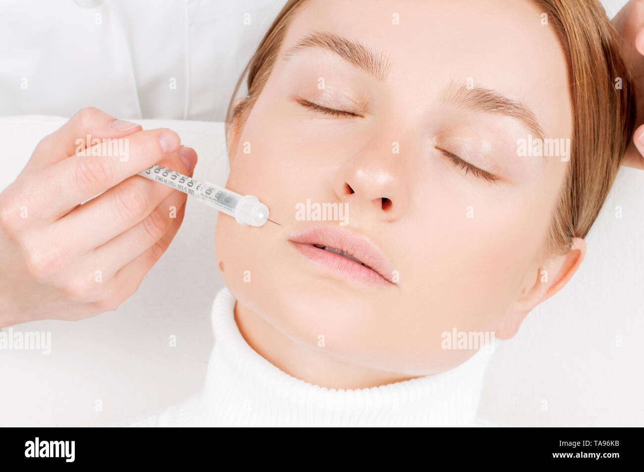 Beautiful woman receiving filler injection in lips. Antiaging