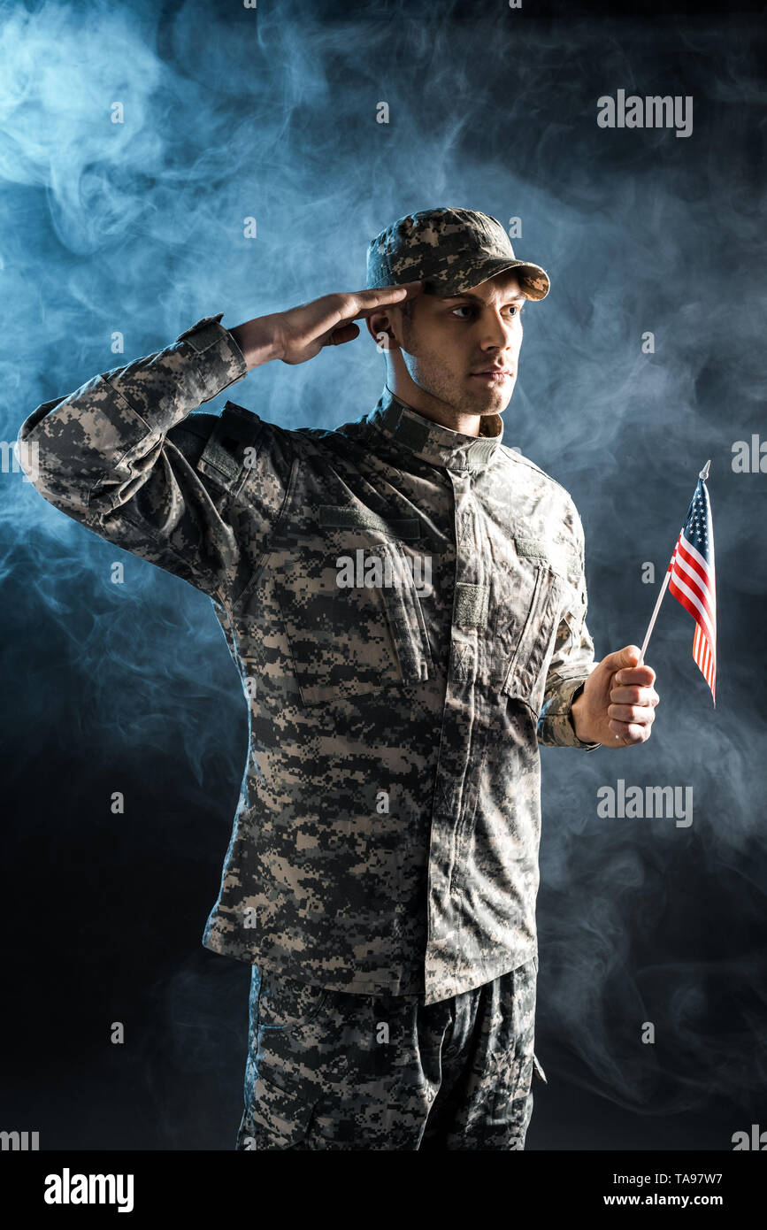 confident soldier in military uniform holding american flag and giving ...