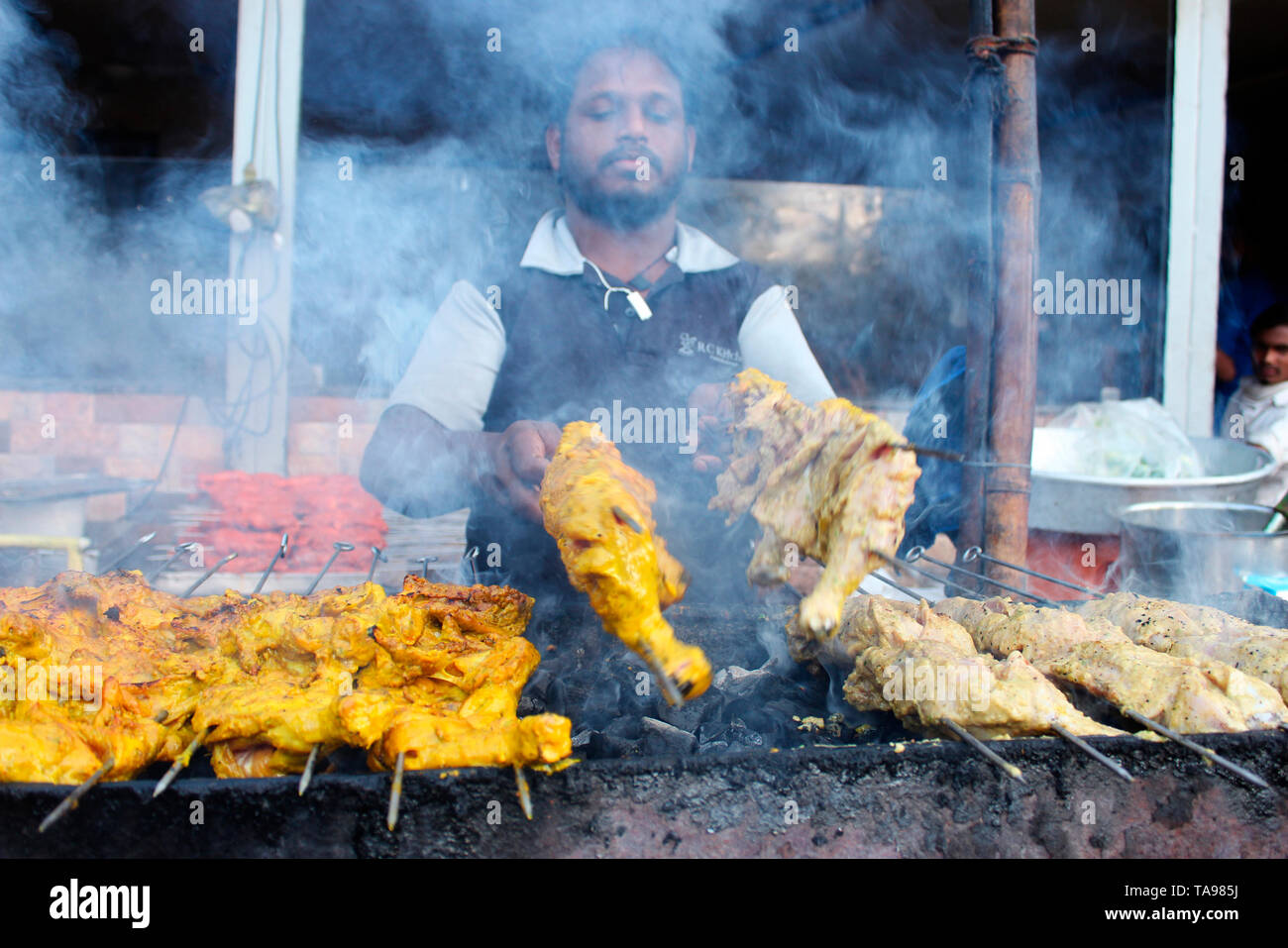 PUNE, MAHARASHTRA, February 2019, Man barbequing chicken at street corner. Stock Photo