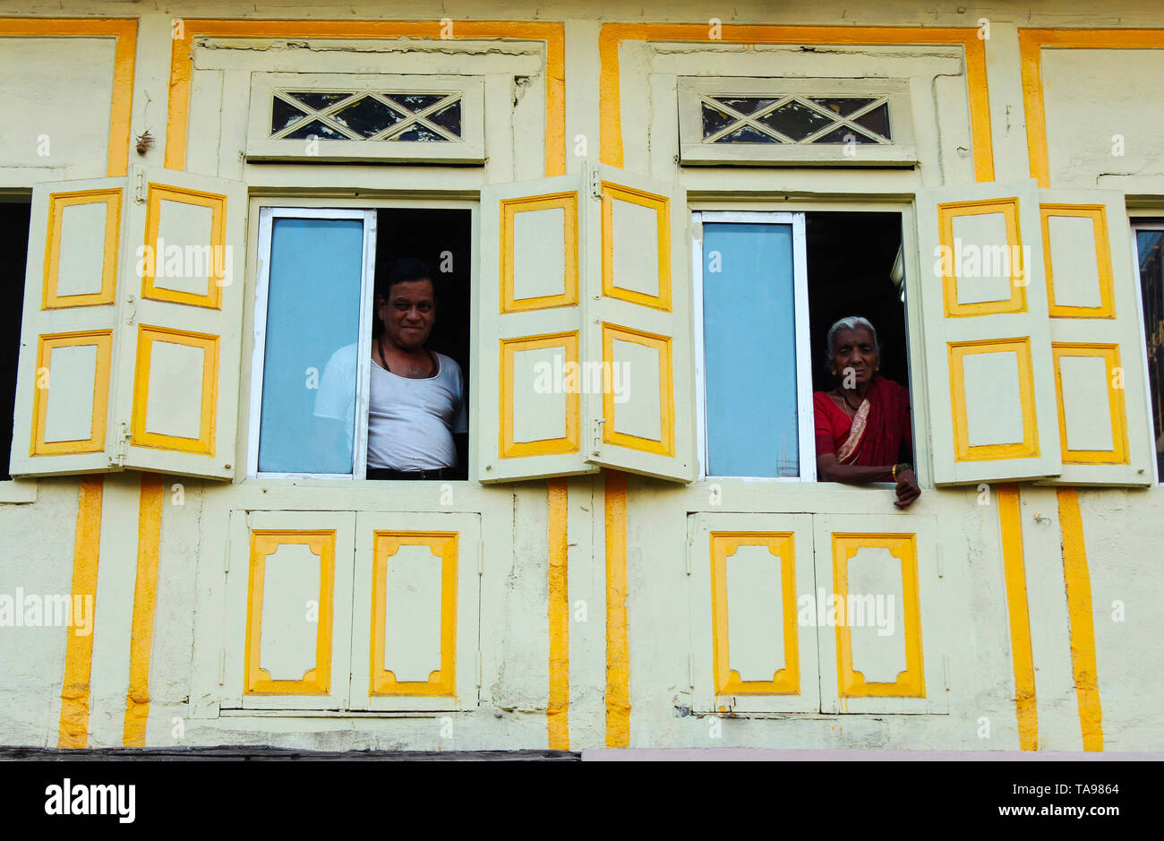 PUNE, MAHARASHTRA, February 2019, Man and old woman looking out from their verandah. Stock Photo