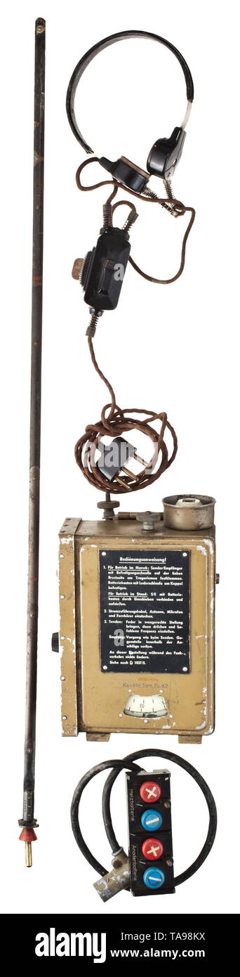 A small radio transceiver d (KlFuSpr. d) 'Dorette' portable radio set in frequency 32.0 - 38.0 Mhz, range 2 - 4 km Metal housing painted in sand-colour with riveted-on operating instructions and nameplate from 1944. Not tested for functionality or completeness. Dimensions ca. 180 x 130 mm. Included is a band antenna, length 72.5 cm, maker 'K & R 43'. Larynx microphone (Kmf. b) with cotton covered, brown cable, breaker with attachment clamp and tri-pole connector. Brown Bakelite supply box with ports for A- and dry batteries and the connector cable with four-pole connector. , Editorial-Use-Only Stock Photo