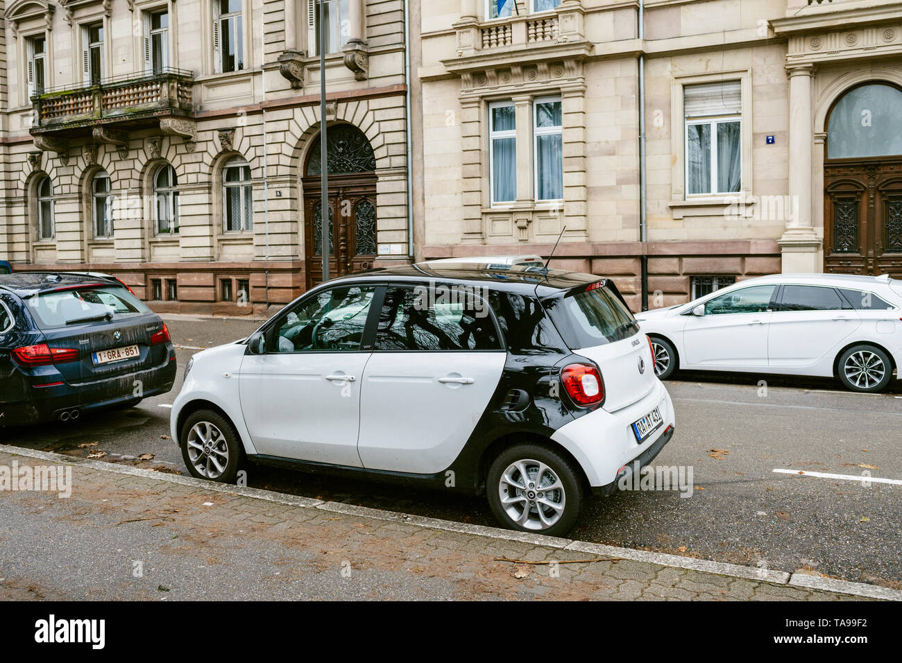 Strasbourg, France - Dec 27, 2017: Parked in the street white Mercedes Smart car - french apartment buildings in the background Stock Photo