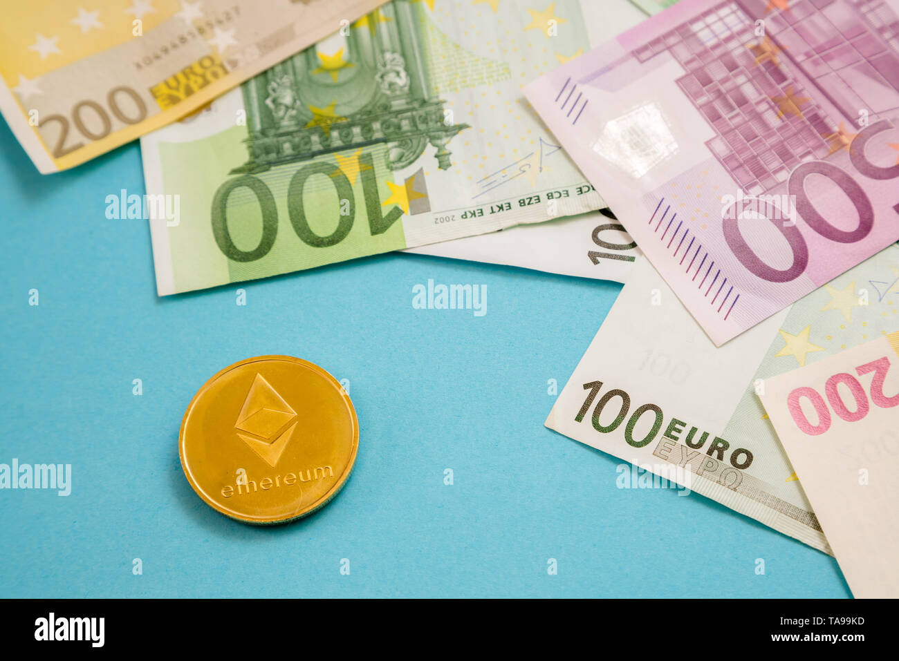 Ethereum coin next to Euro bank notes on blue background. Digital currency,  block chain market. Euro bills next to crypto coin Stock Photo - Alamy
