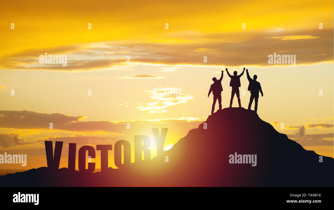 Silhouette of happy teamwork hold hands up as a business successful, business victory. Stock Photo