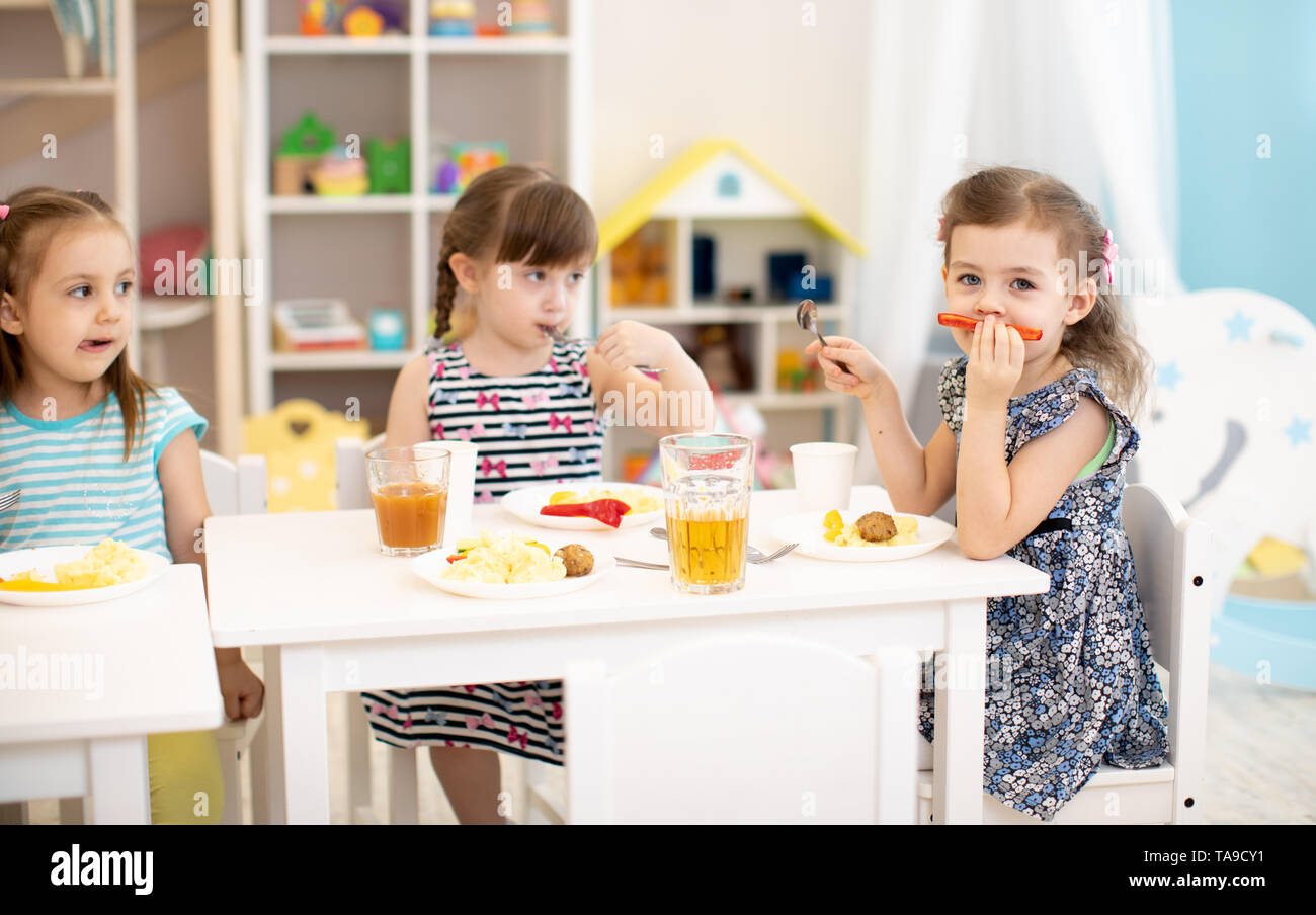 Kids have a lunch in daycare centre. Children eating healthy food in