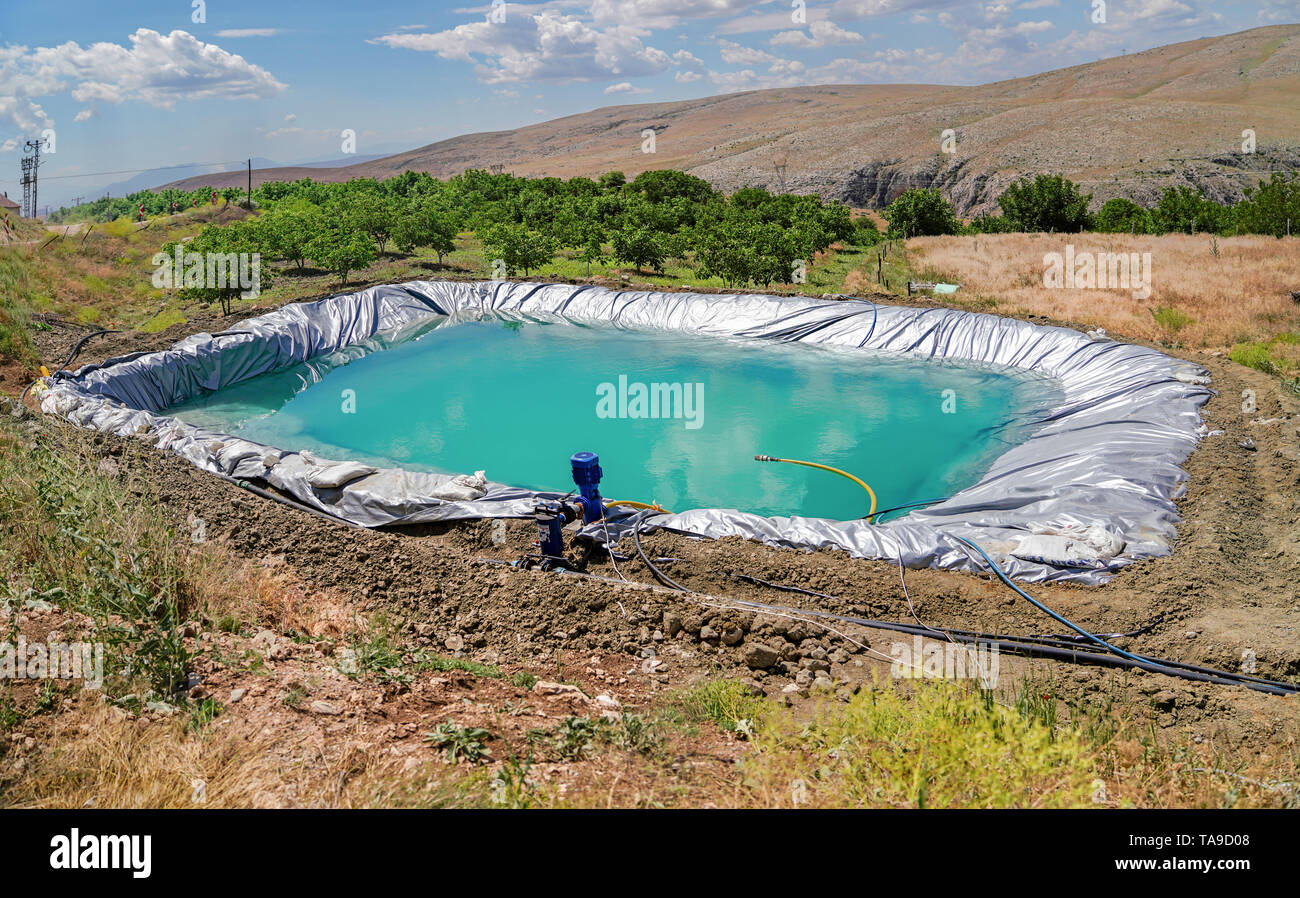 Irrigation reservoir with pipes and pump Stock Photo