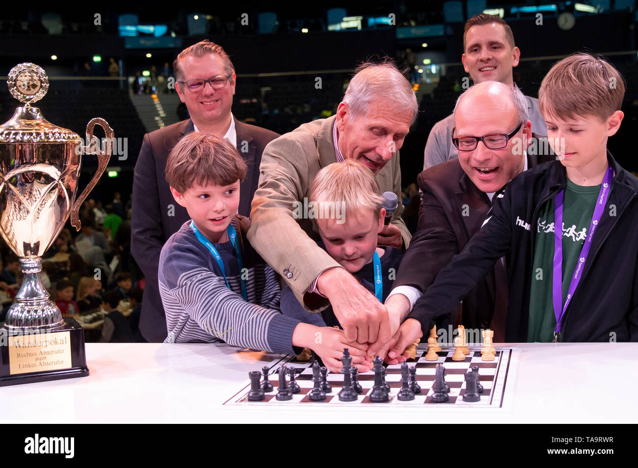 23 May 2019, Hamburg: School senator Thies Rabe (2nd from right, SPD) and ex-day topic moderator Ulrich Wickert (4th from left), together with the pupils Fridjef Hauschild (l-r), Schule in der Alten Forst, Jari Dieckmann, Schule in der Alten Forst, and Thome Teßmann, Schule Genslerstraße, make the opening move of the tournament. In the background are Arndt Franzen (l), Chief Commercial Officer Barclaycard, and Thomas Peters (3rd from right), moderator of the tournament. Around 4000 pupils take part in the 61st edition of the tournament. According to the organizer, it is the world's largest che Stock Photo
