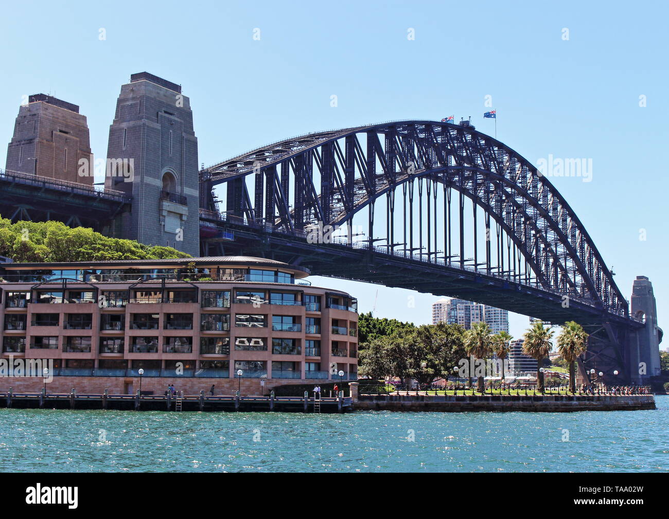 The famous Sydney Harbour Bridge above the Park Hyatt Hotel as captured on a clear day from Campbells Cove in Sydney, NSW Australia Stock Photo