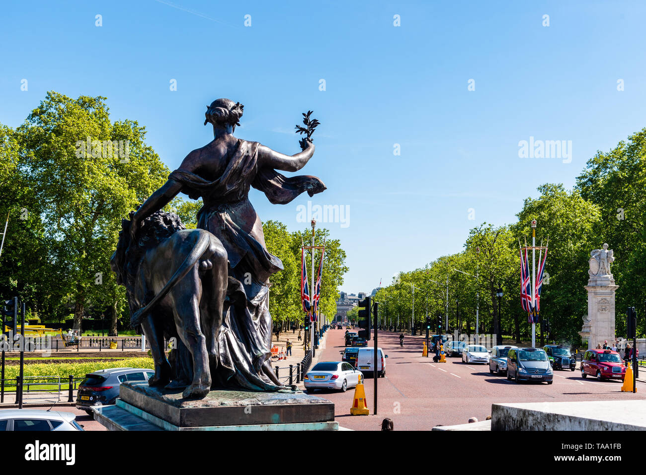 London, UK - May 14, 2019:  Victoria Memorial Sculpture in front of Buckingham Palace a sunny day against The Mall Road Stock Photo