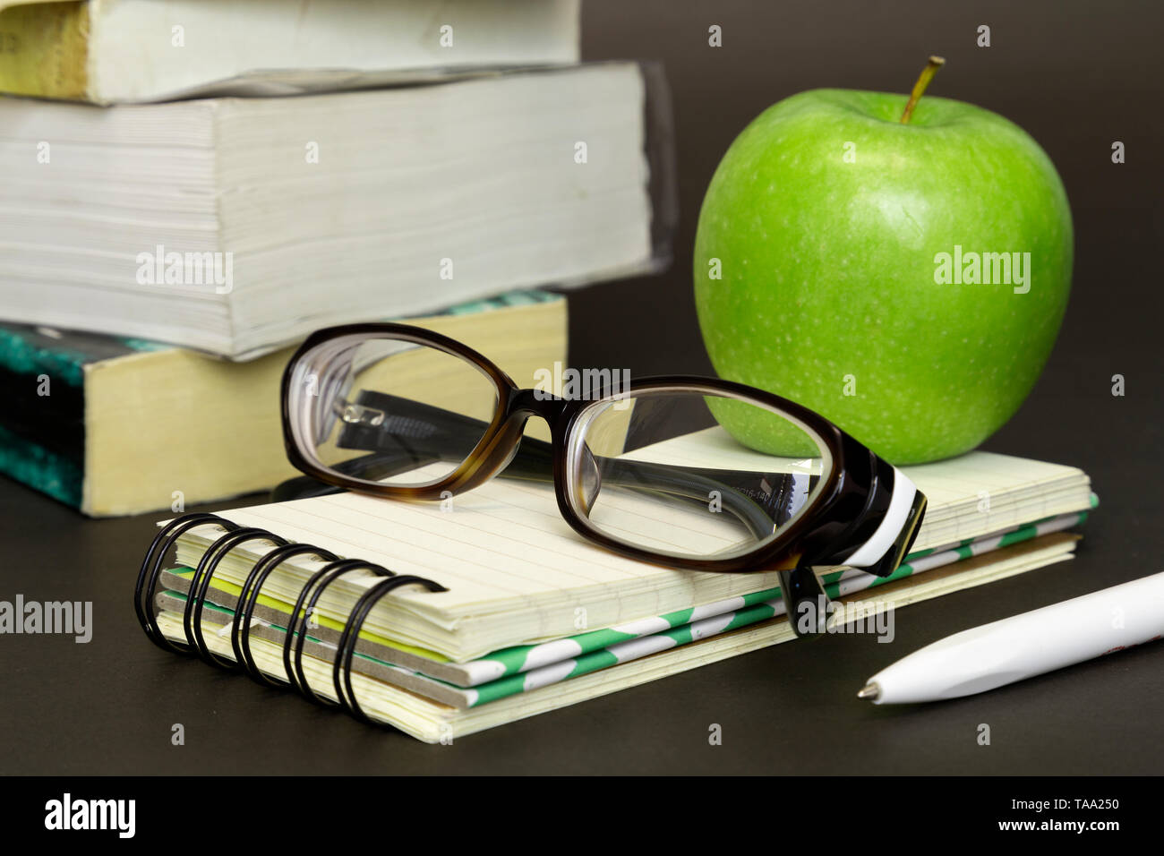 Studying, reading, education with books, glasses and green apple Stock Photo