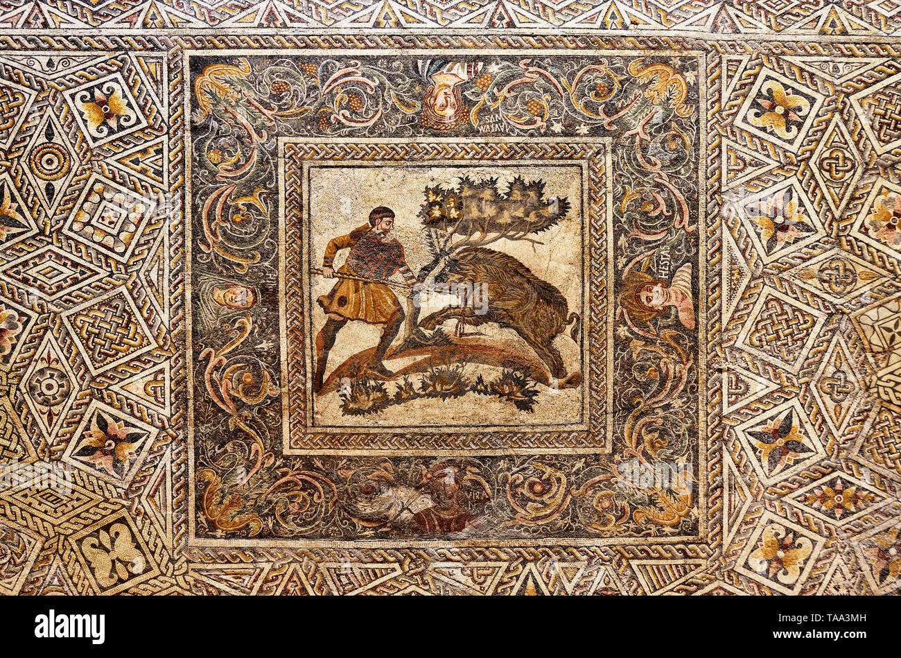 Roman mosaic depicting a hunter and a wild boar. Roman villa 'Las Tiendas', 4th century A.D.. Museo Nacional de Arte Romano (National Museum of Roman  Stock Photo
