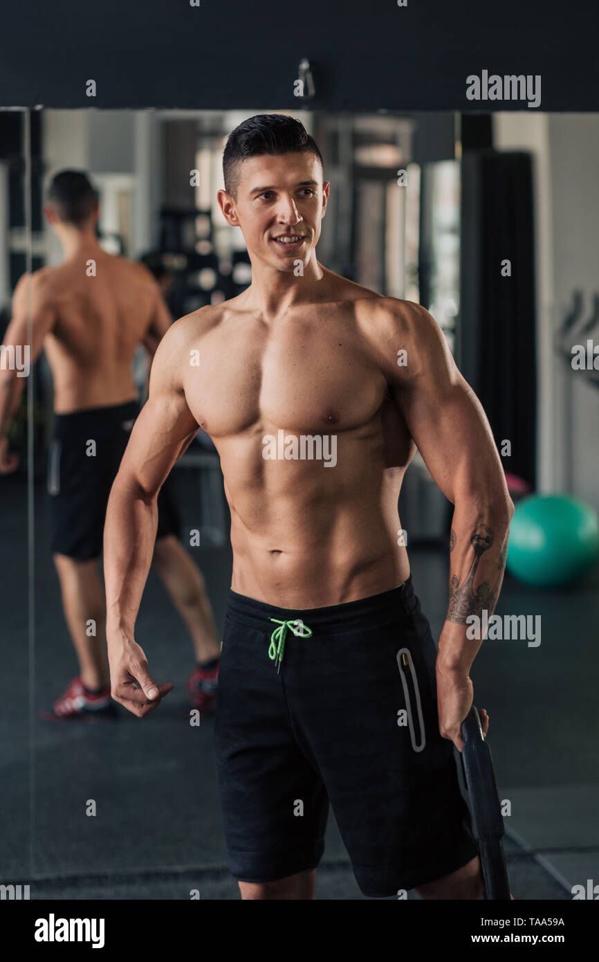 Young muscular man in the gym doing exercise Stock Photo - Alamy