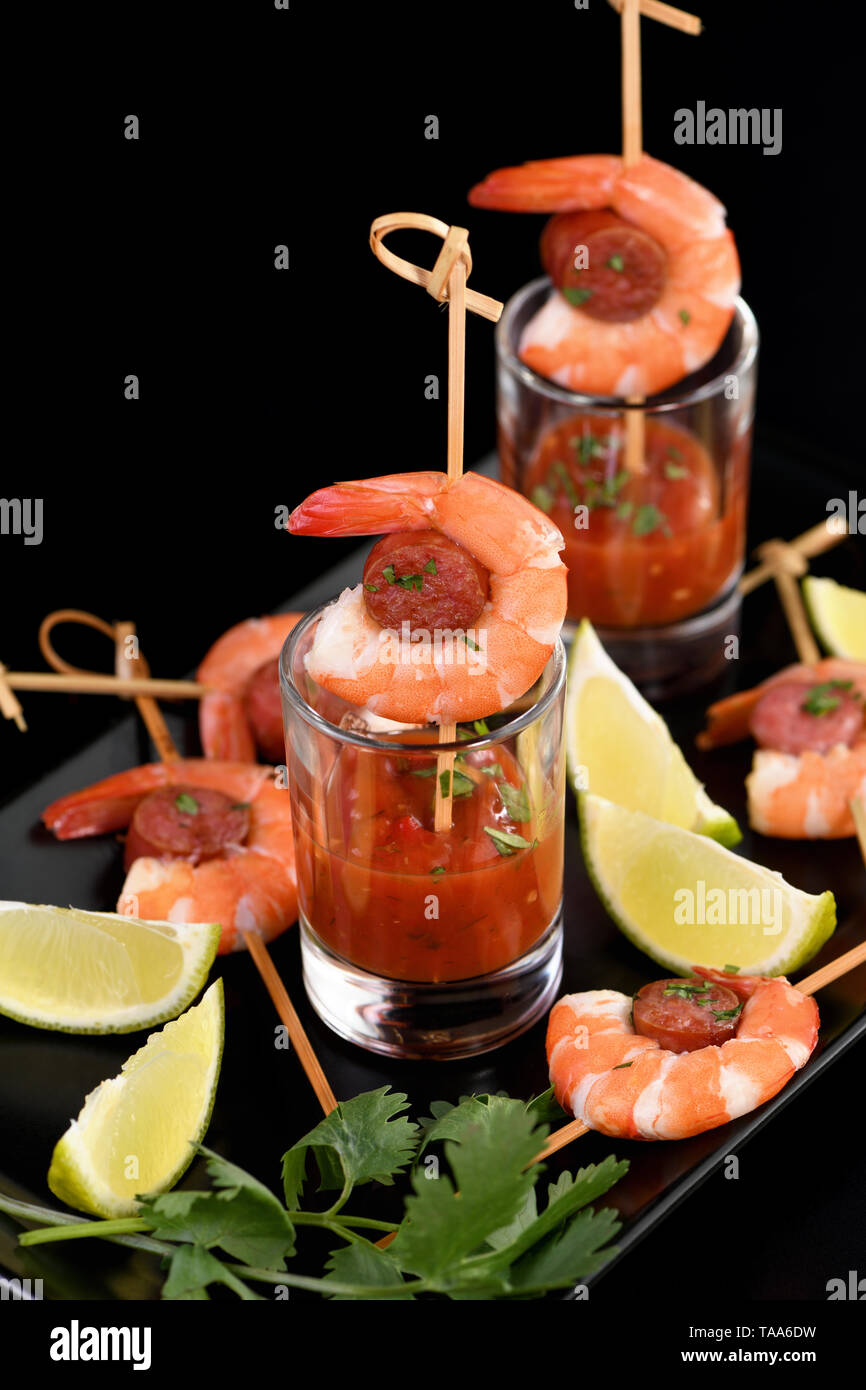 Appetizer of shish kebab with shrimps and chorizo ​​sausages with barbecue sauce in a glass Stock Photo