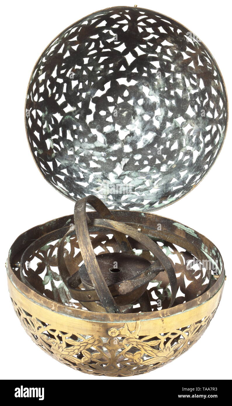 A spherical hand warmer, Nuremberg, 17th century Globe made up of two openworked hemispheres of sheet brass, the two hinged halves fastened with a hook. The front richly engraved with decorative tendrils and birds. A small oil lamp inside the globe with quadruple gimballed mounting. Small repair on one hemisphere. Diameter 13 cm. Rare hand warmer, which was used during the long winters. The gimballed mounting allows the globe to be rotated freely without changing the direction of the lamp. historic, historical, handicrafts, handcraft, craft, obje, Additional-Rights-Clearance-Info-Not-Available Stock Photo