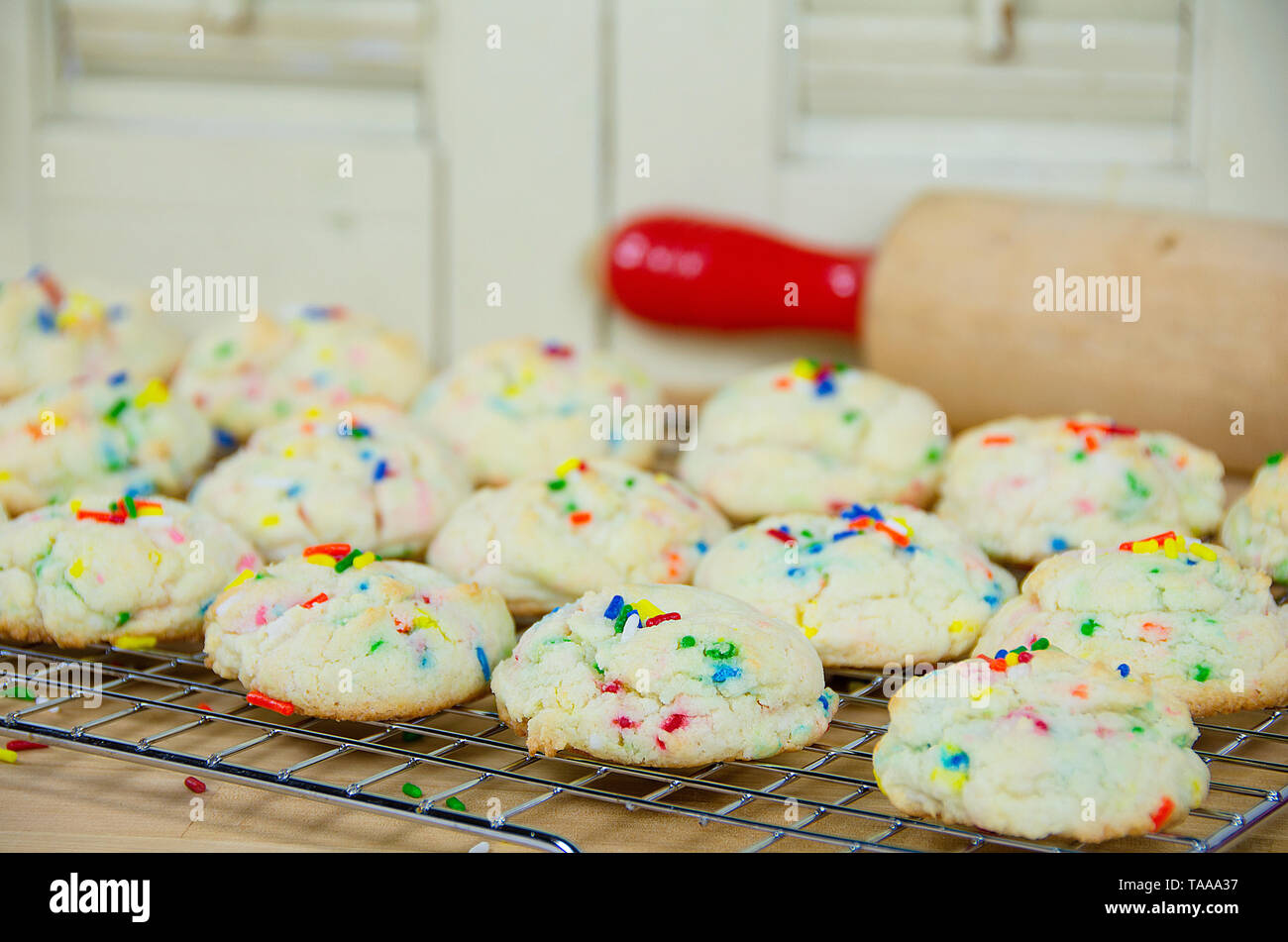 homemade cookies on cooling rack with colorful sprinkles and rolling pin Stock Photo