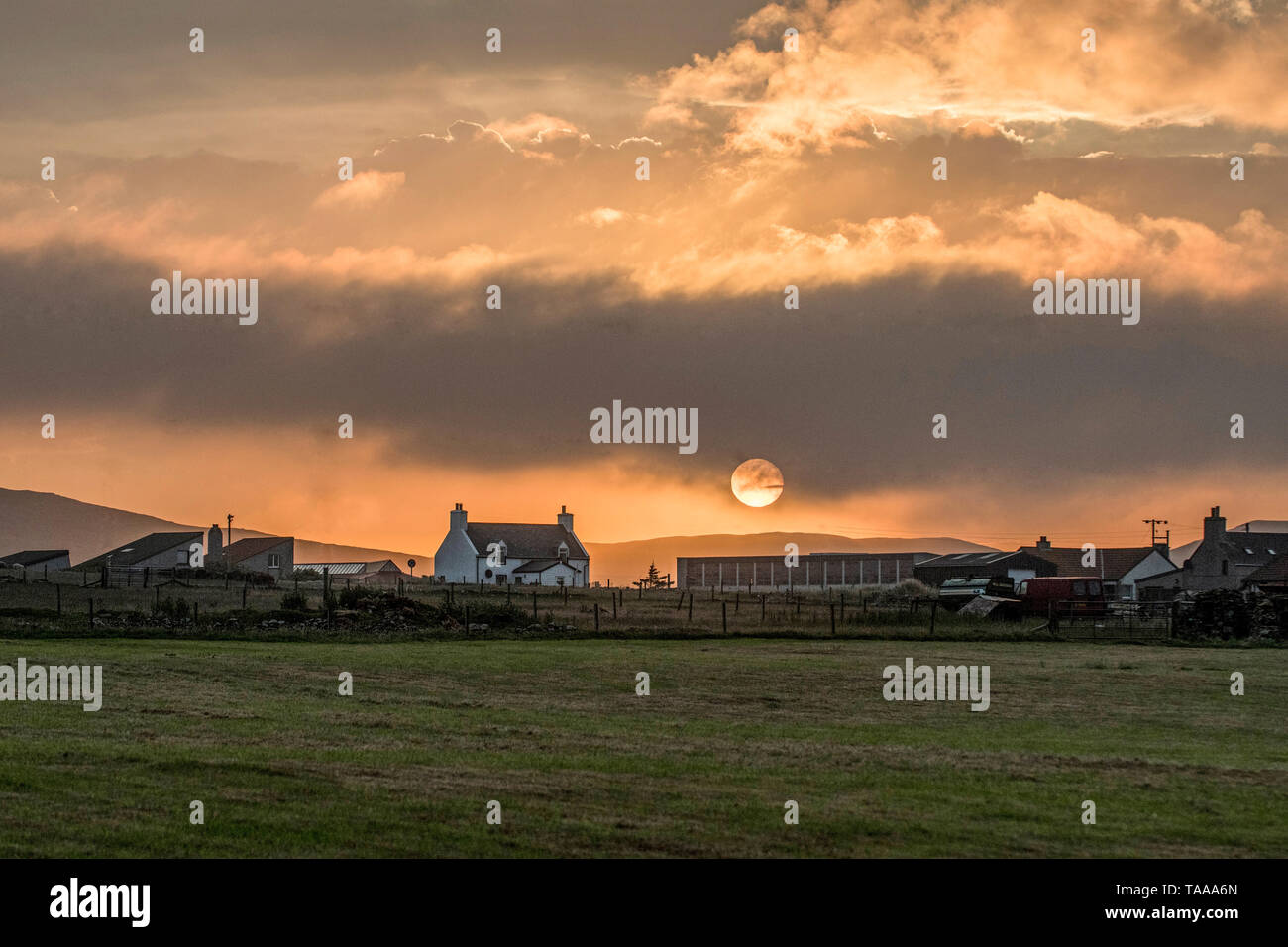 Farmhouse and settig sun, Haroldswick, Unst, Shetland Stock Photo