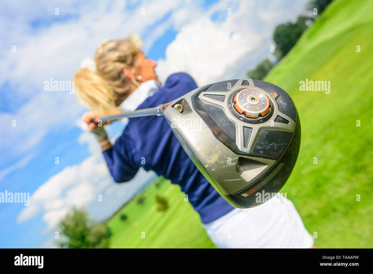 Blonde woman hitting a golf ball from tee with driver Stock Photo Alamy