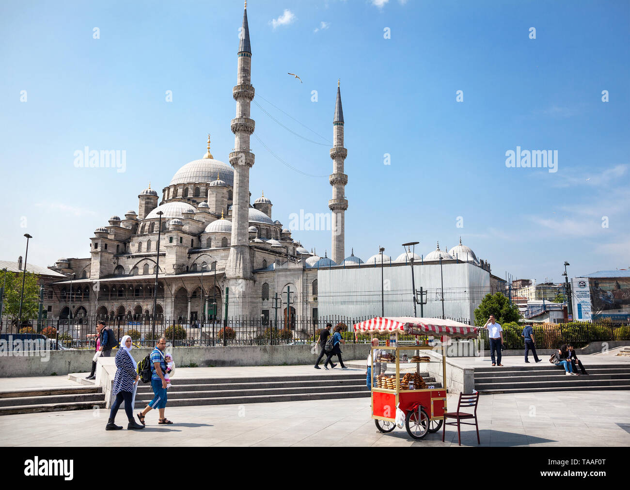 ISTANBUL, TURKEY - MAY 23, 2016: Street Vendor and tourist walking in front of Yeni Cami, New Mosque near Galata Bridge Stock Photo