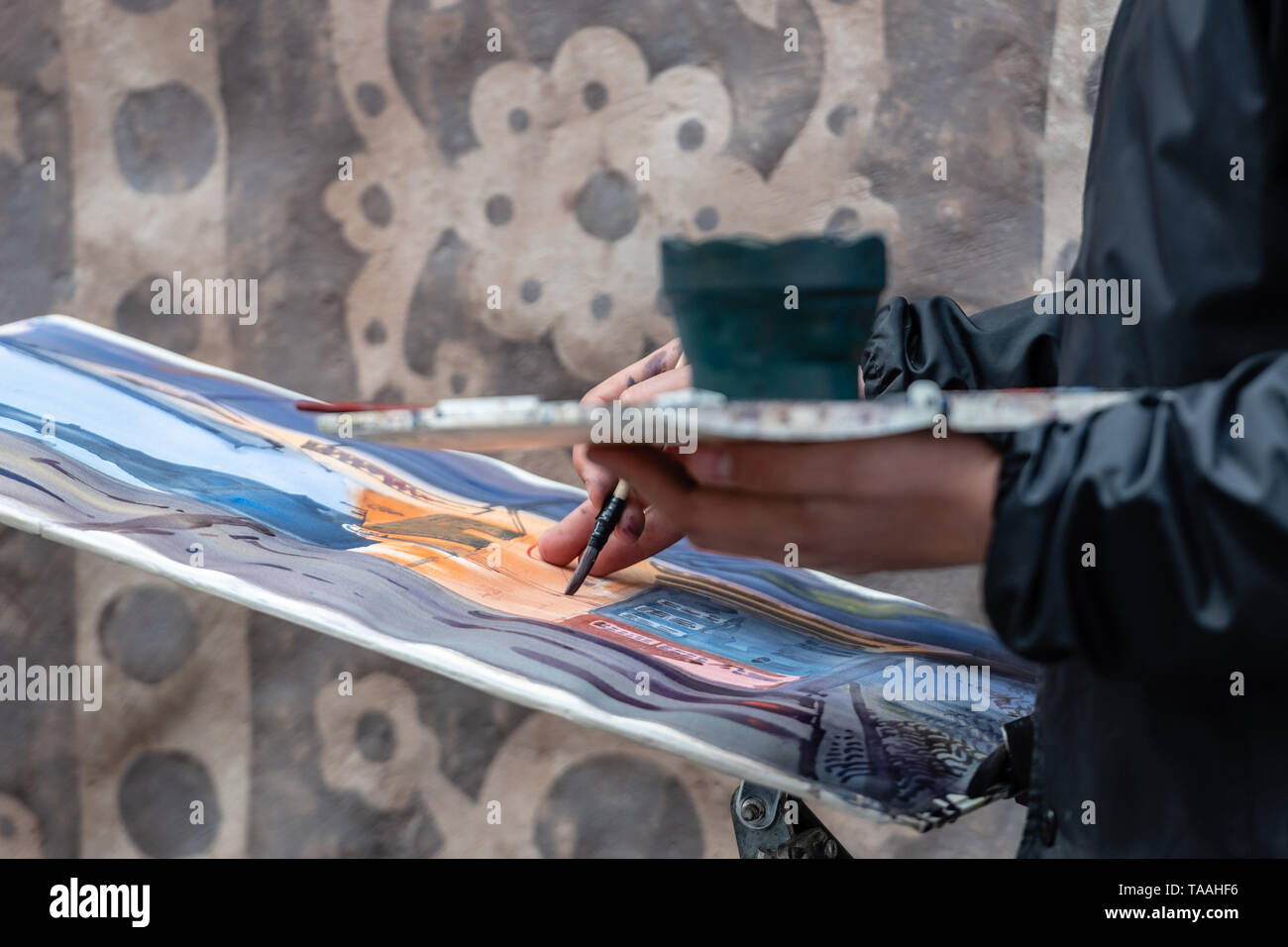 Artists hand with brush and palette painting street scene Stock Photo ...