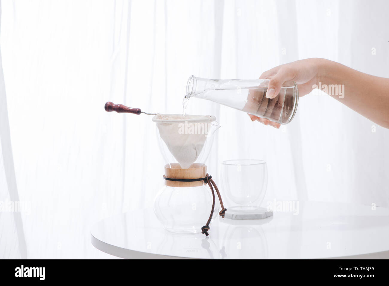 Pouring Water to the Coffee Pot on White Wall and White Table, Manual Brew, Hand Drip Coffee Stock Photo