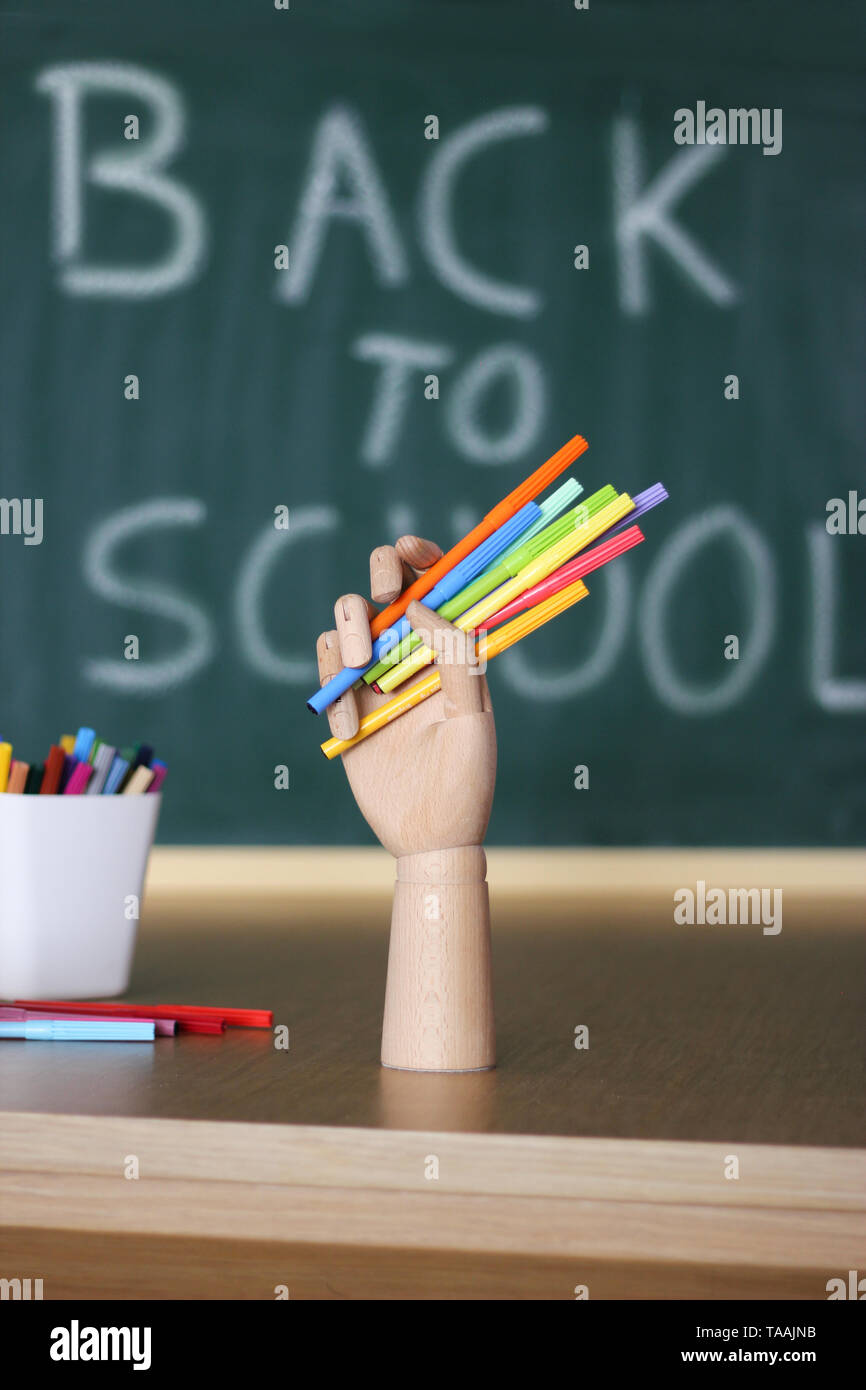Back to school.Articulated wood hand holding markers Stock Photo Alamy