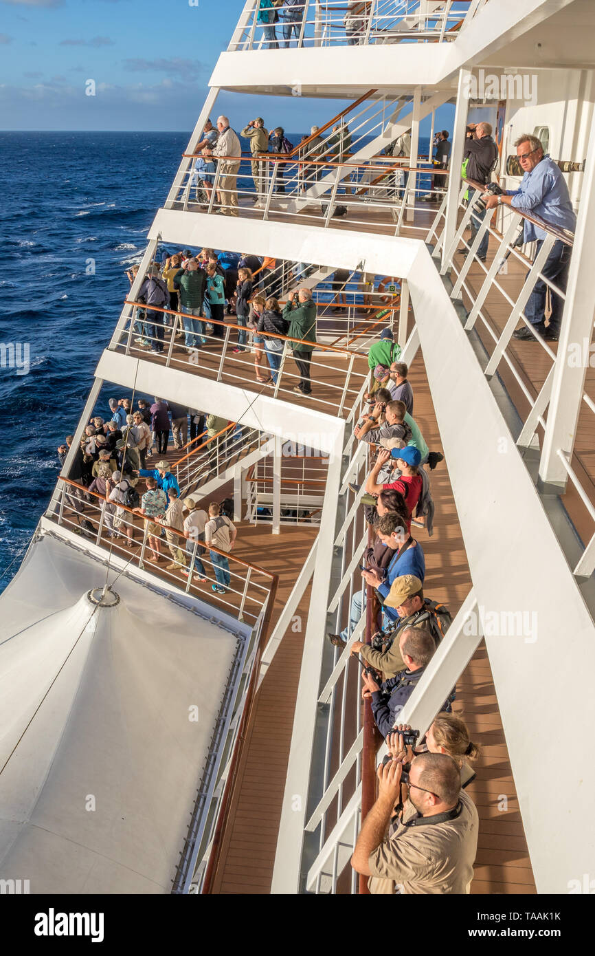 Cape Town, South Africa - unidentified passengers on a cruise liner watch fro the aft decks as the ship departs image in portrait format Stock Photo