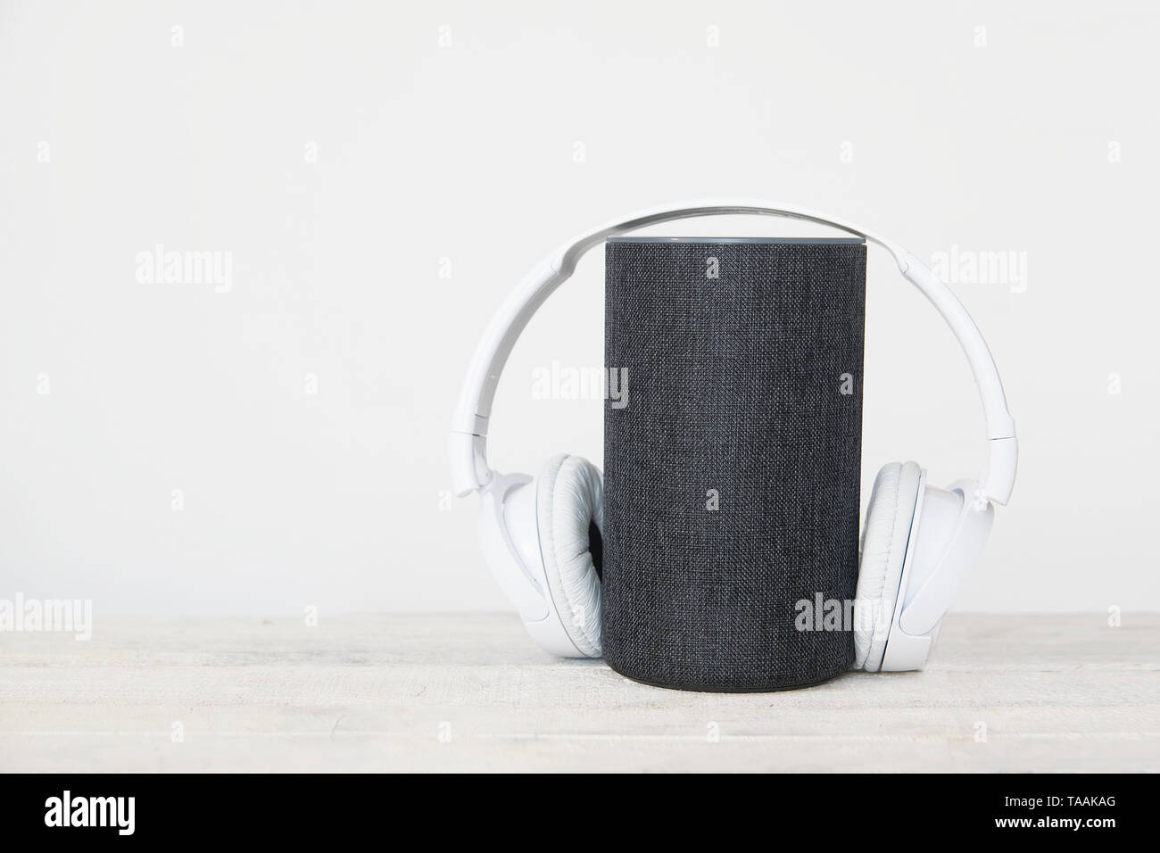 Smart speaker device and hearphones against a white background. Empty copy space for Editor's text Stock Photo