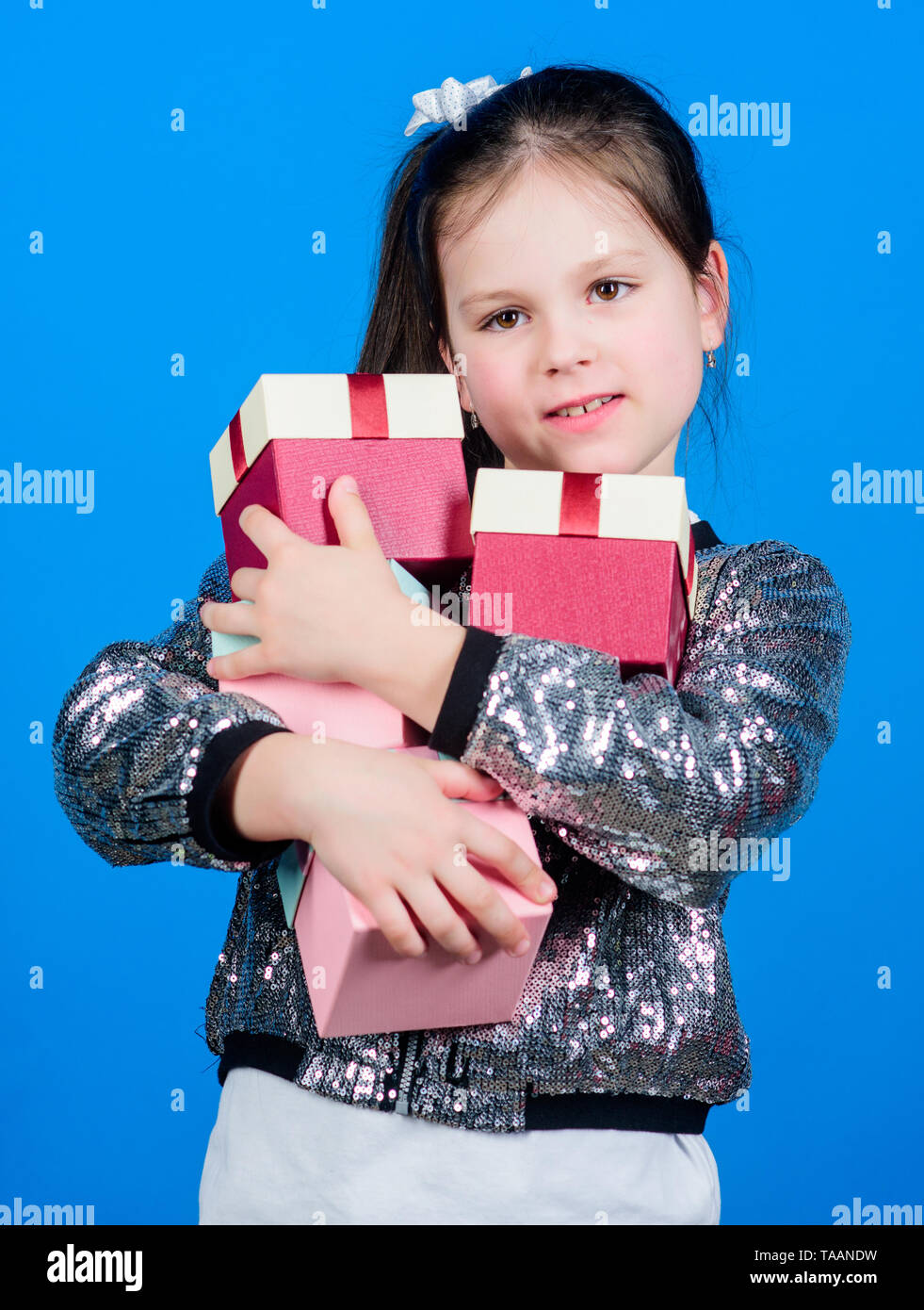 Black friday. Shopping day. Child carry lot gift boxes. Kids fashion. Surprise gift box. Birthday wish list. Special happens every day. Shop for what you want. Girl with gift boxes blue background. Stock Photo