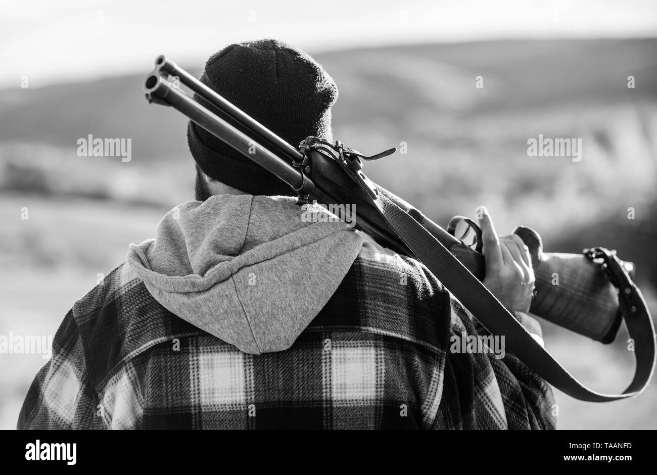 Man brutal guy gamekeeper in hat nature background. Brutality and