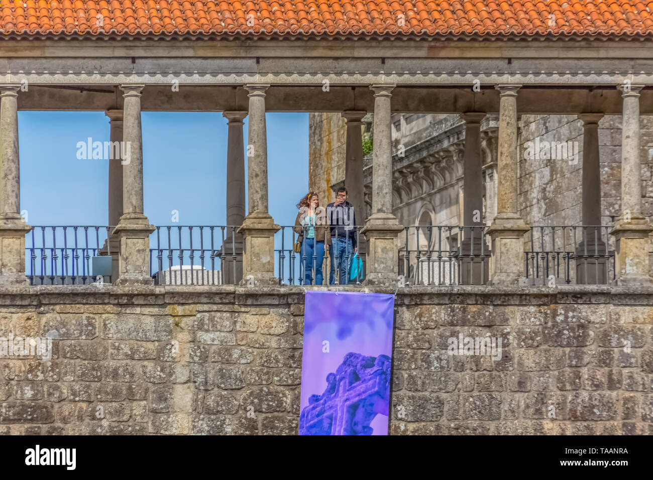 Viseu / Portugal - 04 16 2019 : Detailed view at the lateral facade of the Cathedral of Viseu, Sé Cathedral de Viseu, column gallery with a couple, ar Stock Photo